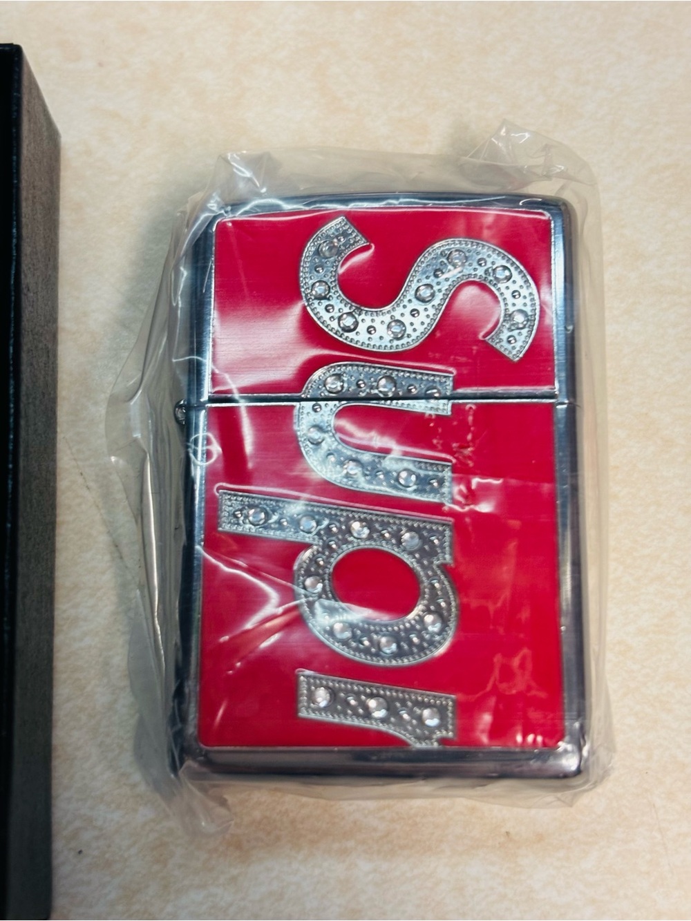 Supreme Swarovski Zippo with Swarovski crystal and enamel logo.